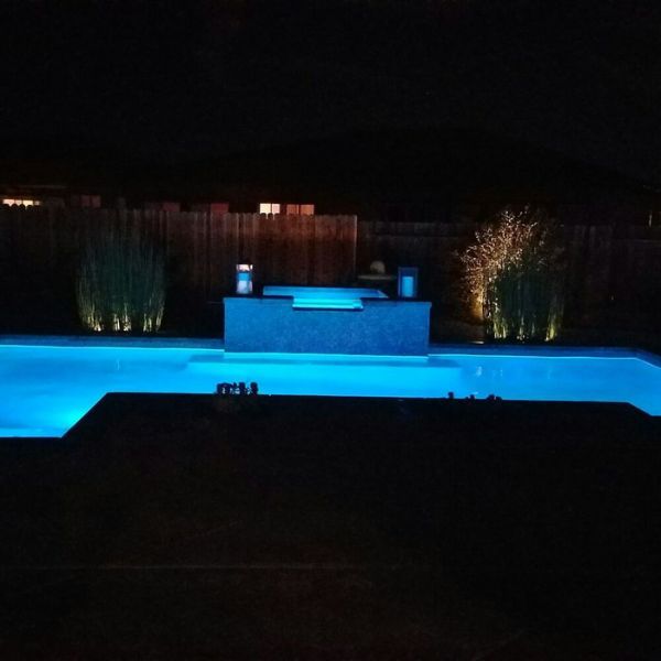 A swimming pool with lights at night