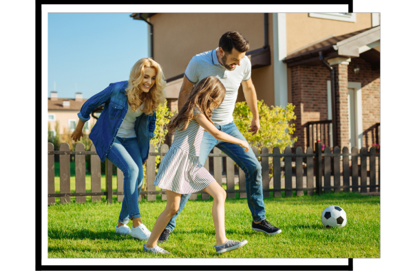 family playing with soccer ball in yard