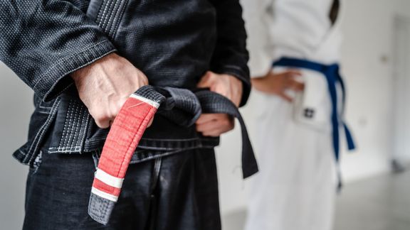 man holding jiu-jitsu belt