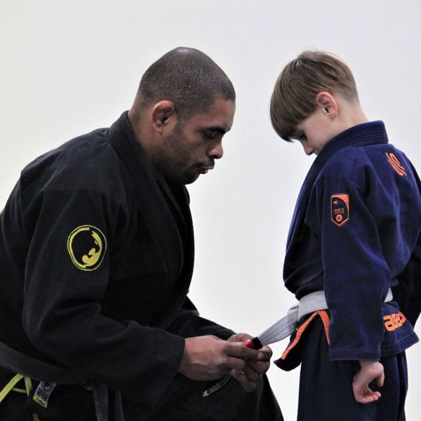 instructor helping student tie belt