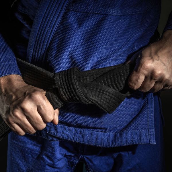 man tying a jiu-jitsu belt