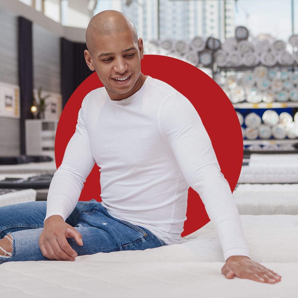 A young man shopping for a new mattress