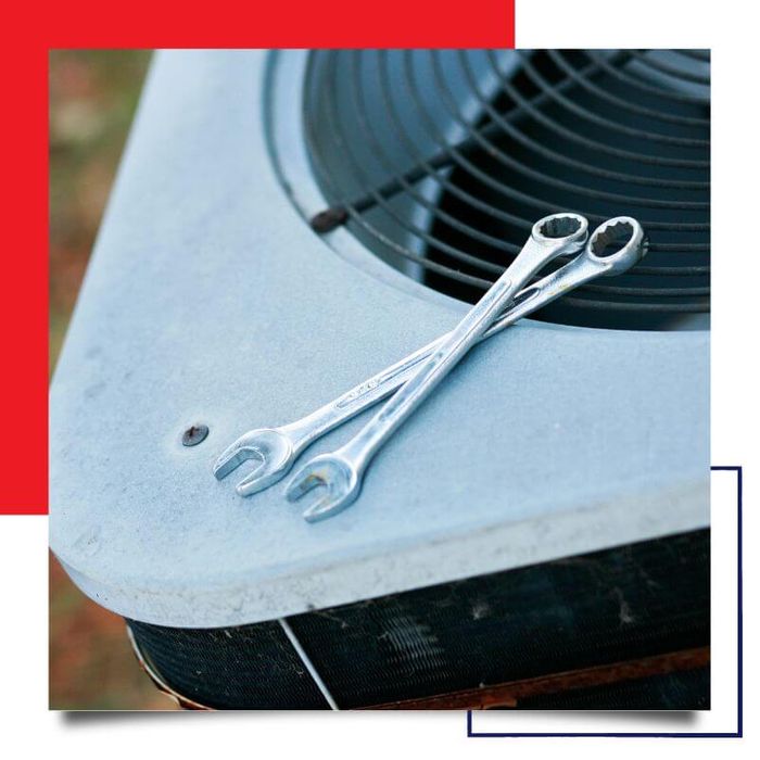two wrenches on top of air conditioner