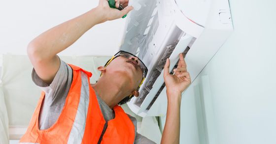 HVAC tech examining a mini split unit