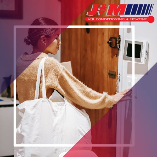 A woman looks at her wall mounted thermostat