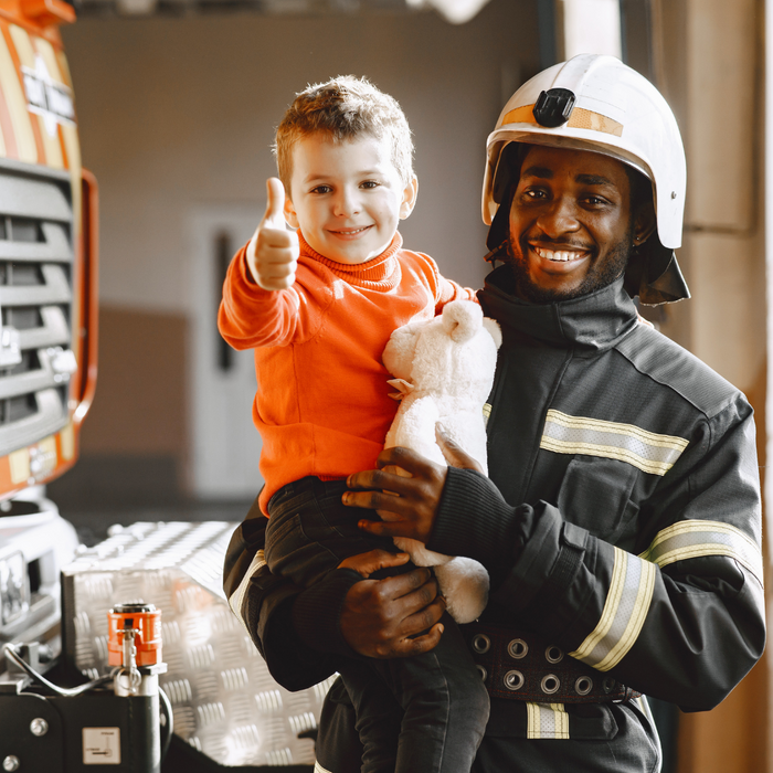 firefighter holding a kid