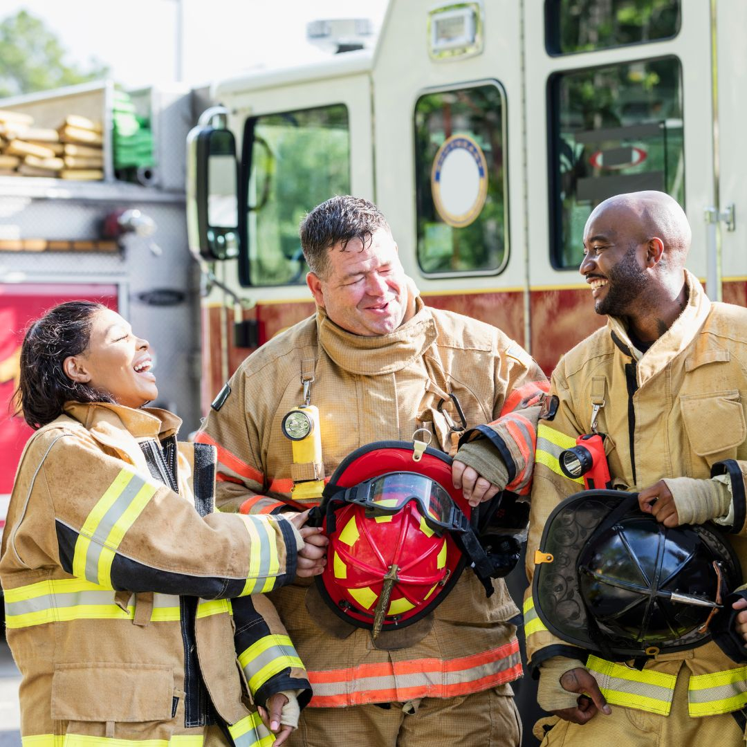 Three firefighters talking and laughing