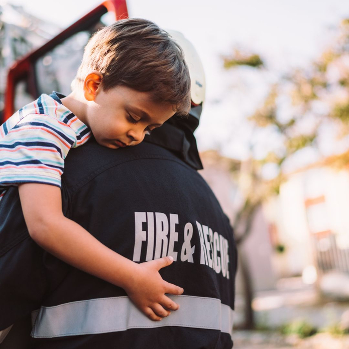 firefighter carrying a boy