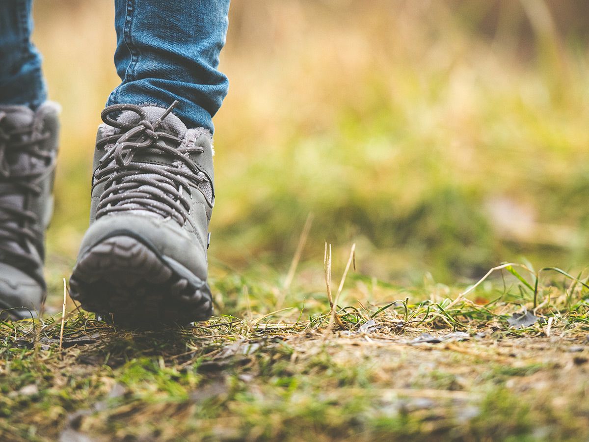 A close-up image of hiking boots on a grassy trail.