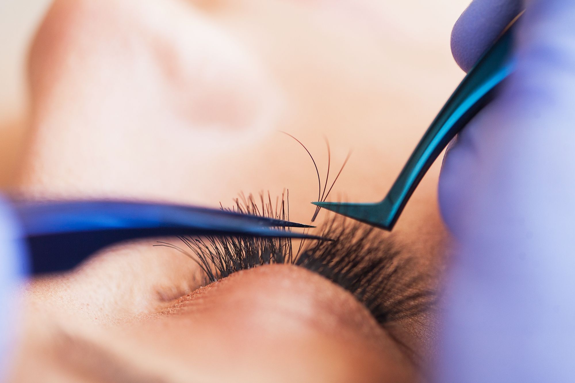 Professionally-trained esthetician applying eyelash extensions at a med spa.