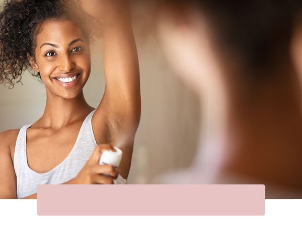 Woman spraying deodorant on her hairless armpit