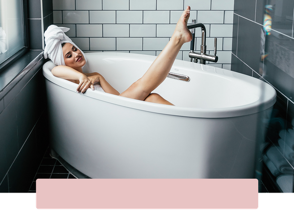 Woman pointing her hairless leg out of the bath tub