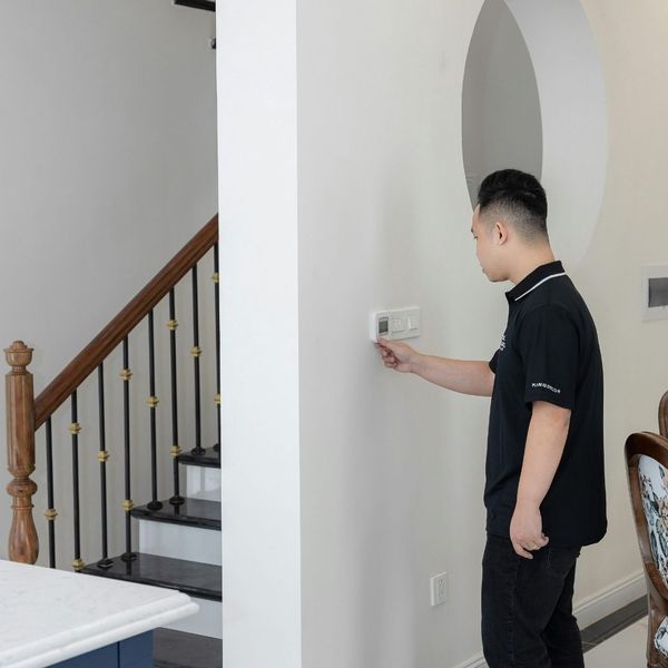 man adjusting thermostat