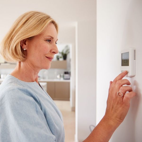 woman adjusting the thermostat