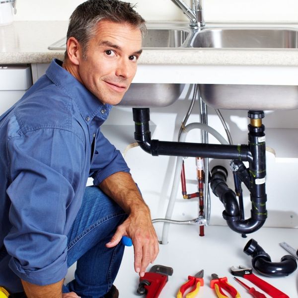 plumber at sink, turning to smile at camera How to Choose the Right Plumbing Service Provider 1.jpg