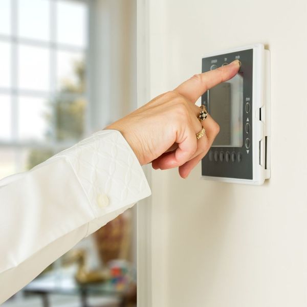 person adjusting thermostat