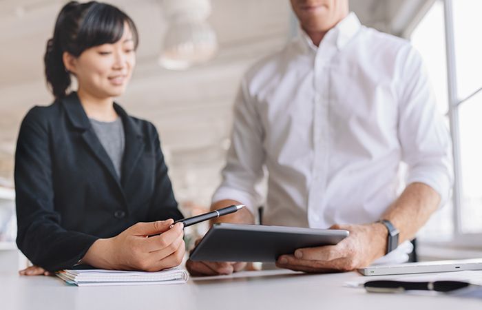 business people looking at a tablet and having a discussion