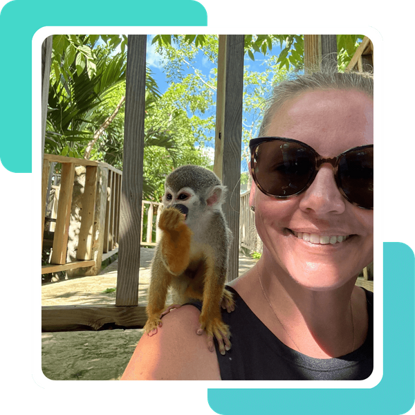 Owner of RJ Travel smiling with a friendly squirrel monkey perched on her shoulder during an excursion in the Dominican Republic. Owner of RJ Travel smiling with a friendly squirrel monkey perched on her shoulder during an excursion in the Dominican Republic.