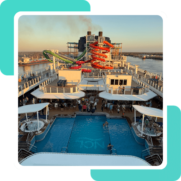 Top deck of a cruise ship featuring a lively pool area and colorful, winding water slides. Top deck of a cruise ship featuring a lively pool area and colorful, winding water slides.