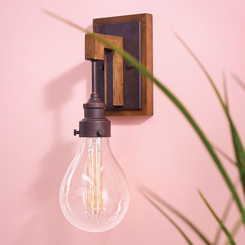 An modern industrial sconce on a pink wall