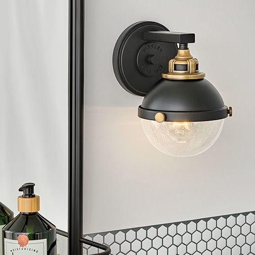 A modern black industrial sconce in a bathroom