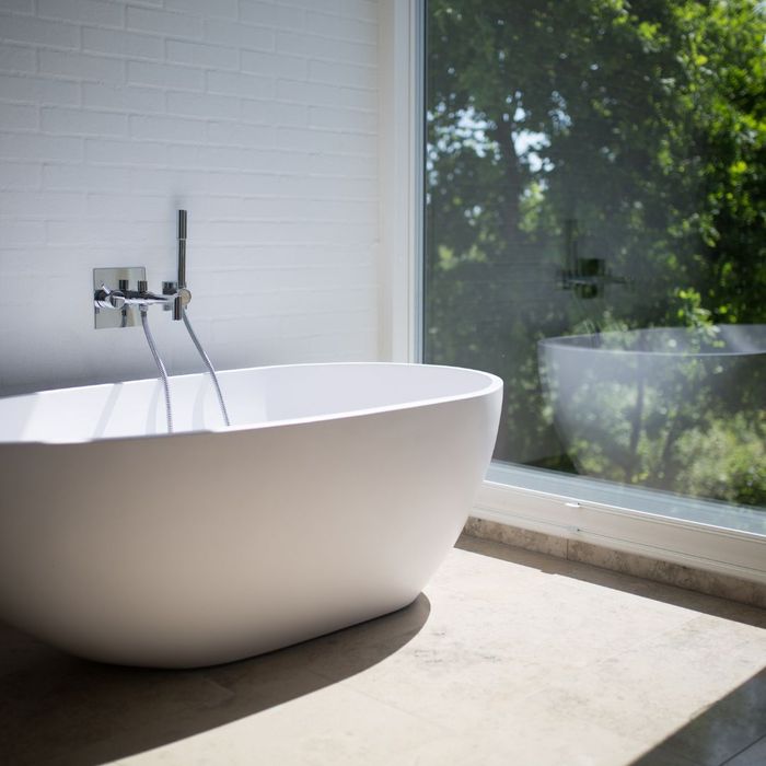 bathtub in front of large window