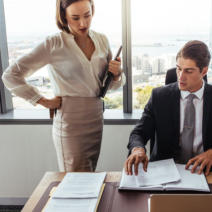 two business people discussing contract documents together in office