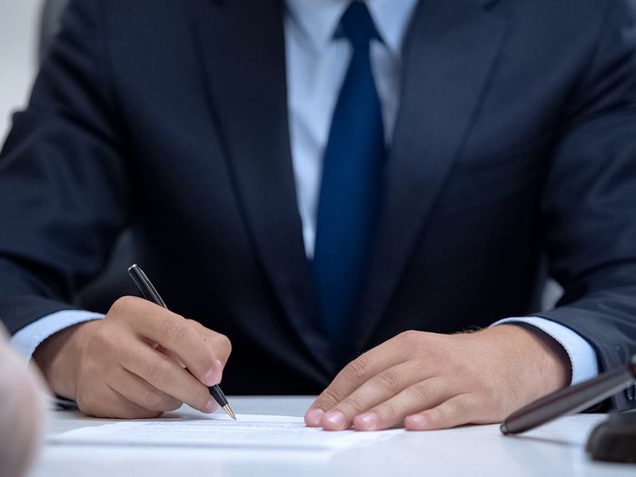 Male lawyer writing down clients testimony to make legal case, close-up