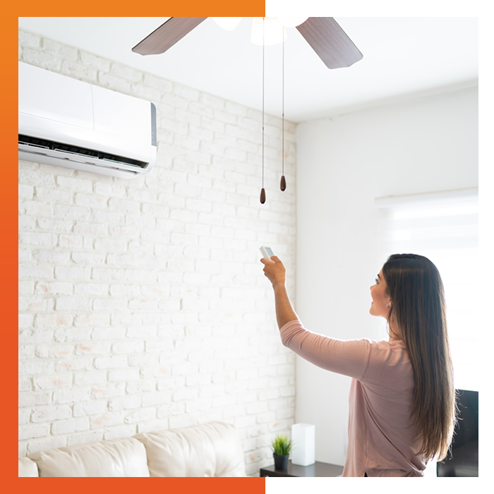 Happy woman using a remote to control her new air conditioning unit