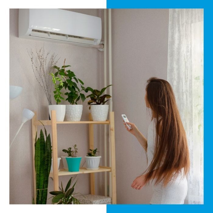 woman turning on mini split ac unit