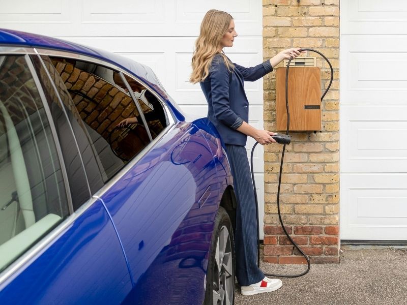 Woman charging her car at home