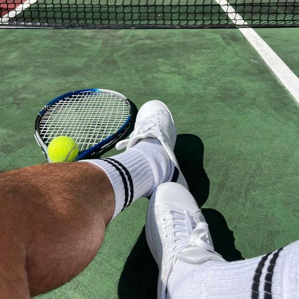 Person showing tennis shoes on the court