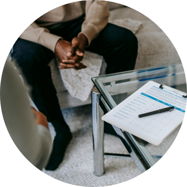 close up of man's clasped hands in therapy session