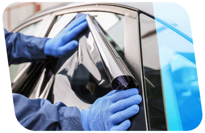 Person applying window tint film to car window