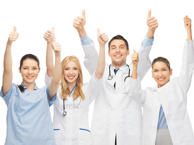 A group of doctors putting two thumbs up in the air and smiling.