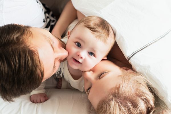 Couple kissing baby on each side of cheek.jpg