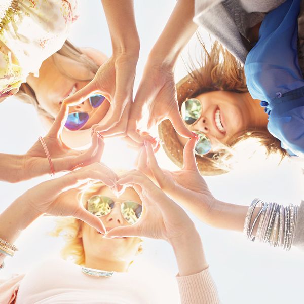 A group of young women making heart shapes with their hands.