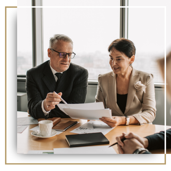 Two business professionals looking at papers.