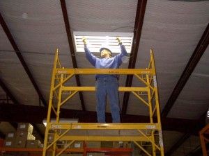 employee on scaffolding changing bulbs