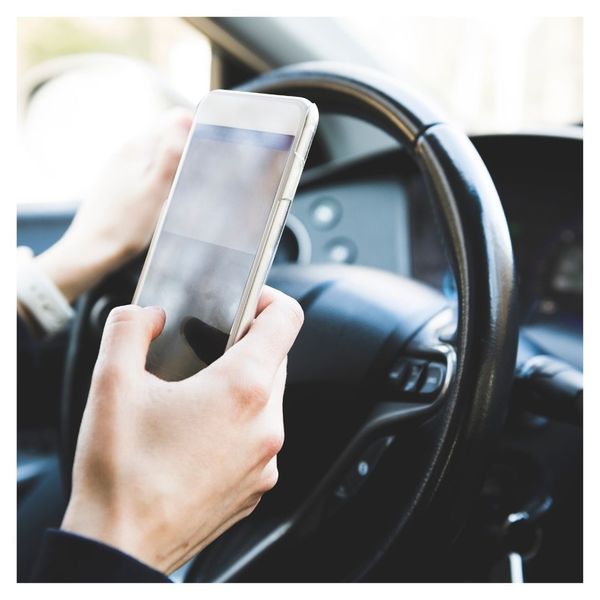 person looking at phone in car