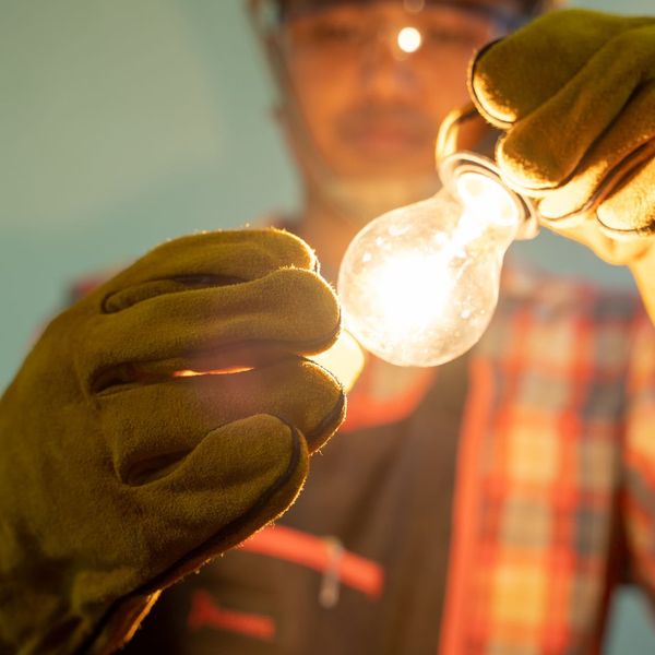 professional holding a lightbulb professional holding a lightbulb