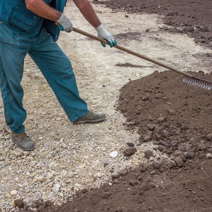 photo of man leveling out dirt