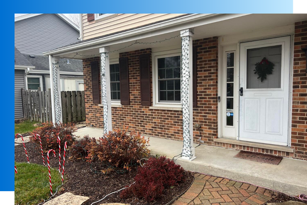 front of brick home showing front door and Christmas lights 