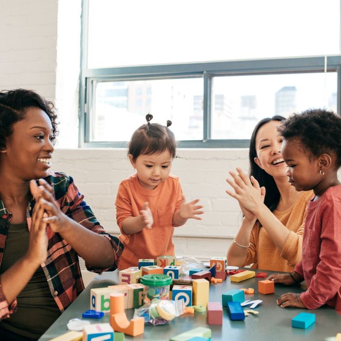 Daycare workers playing blocks with children
