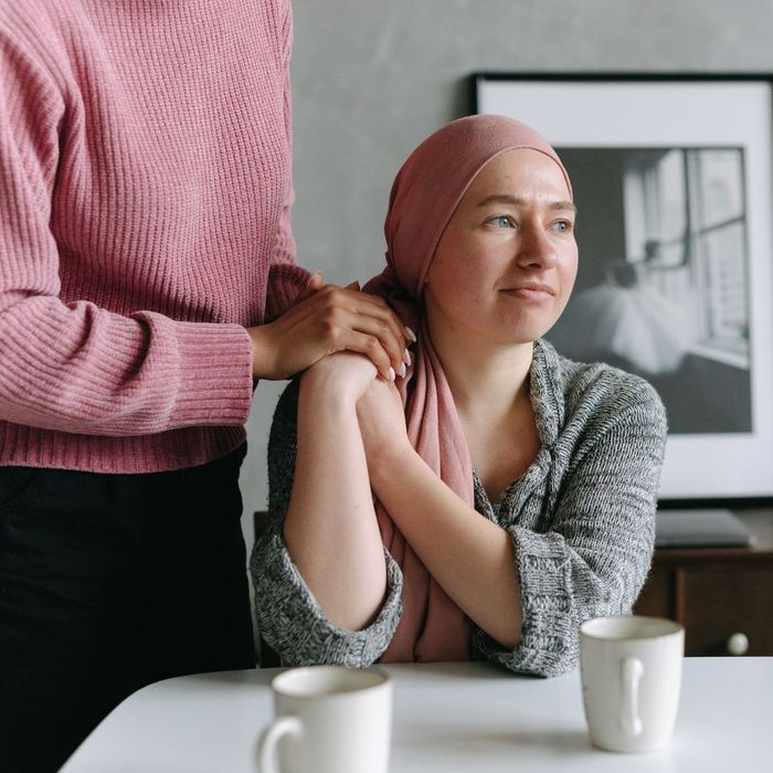 A woman with cancer being comforted by a loved one A woman with cancer being comforted by a loved one