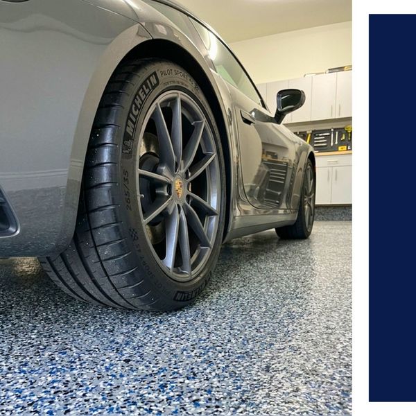 Car wheel on blue and grey speckled epoxy garage floor