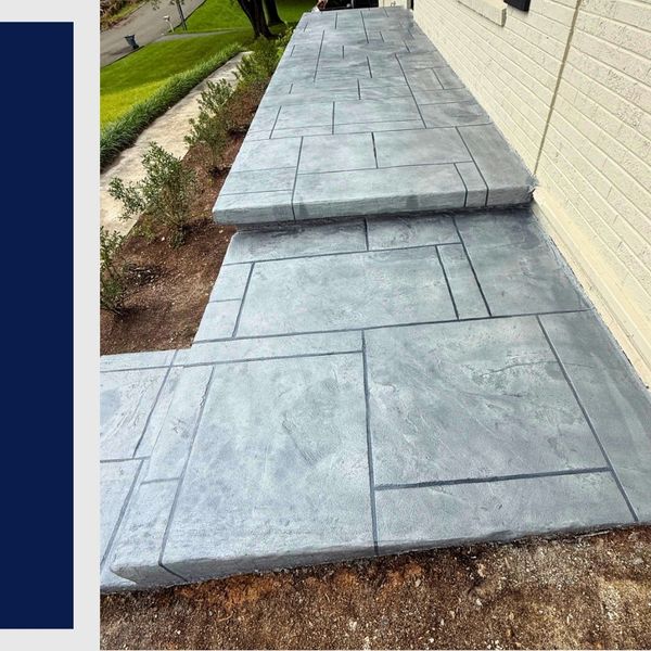 Stamped concrete walkway and steps leading along a brick house.
