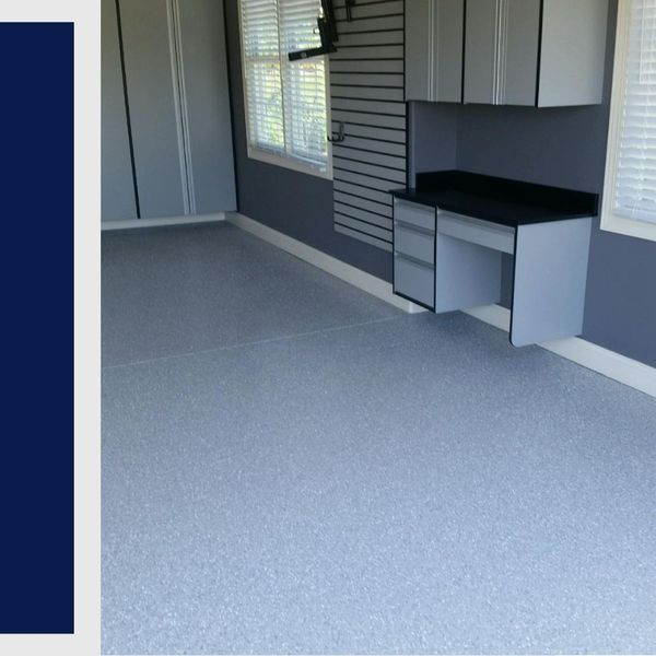 Light grey epoxy garage floor with matching cabinets and desk