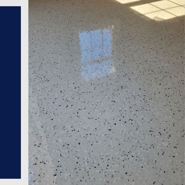 Reflective light tan epoxy flooring with multi-colored decorative flakes showing window light reflection.