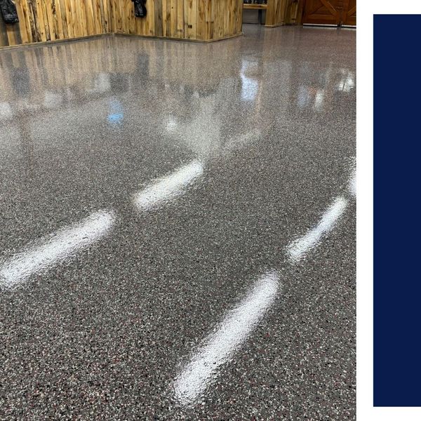 High-gloss decorative flake epoxy garage floor with reflective finish and rustic wood wall paneling.